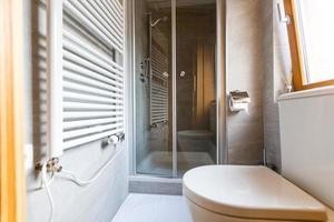 cuarto de baño moderno y espacioso con azulejos brillantes con inodoro y lavabo. vista lateral foto