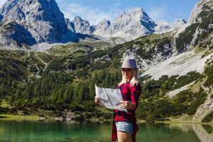 Adventurous Girl navigating in with a Topographic Map in the beautiful Mountains of the Austrian Alps photo
