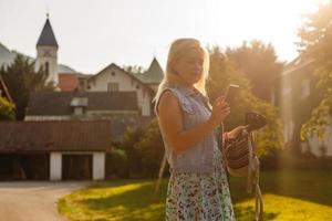 joven mujer es en pie por de madera casas pueblo en montañas. viajar, estilo de vida concepto. Alpes, Europa. foto