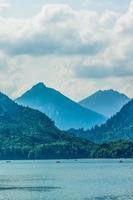 descanso en un montaña lago cerca Neuschwanstein. familia es sentado en el barco foto