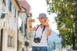 hermosa turista dama vistiendo sombrero y mochila disfrutando maravilloso ver en bávaro montañas cerca Neuschwanstein castillo en Alemania. de viaje concepto. naturaleza ver foto