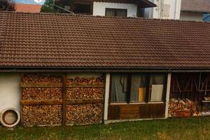 Firebox in the garden. A lot of firewood is stacked in a high firebox. Energy Saving Technologies photo