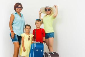 un contento familia con su maletas en un blanco antecedentes foto