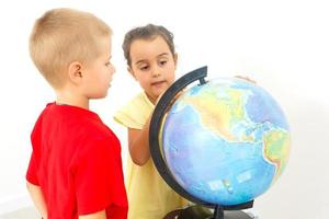 Two elementary school students looking at globe photo