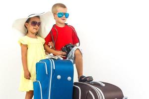 The young traveler kids with a suitcase. Isolated over white background photo