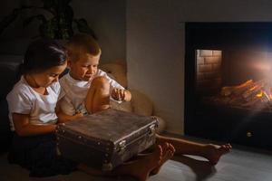 happy children with magic gift at home near fireplace photo