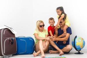 Concept travel and tourism. happy family with suitcases near empty wall photo