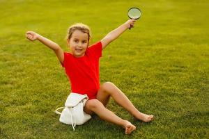 pequeño niña explorador naturaleza mediante el aumentador vaso al aire libre foto