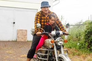 contento abuelo y su nieta en hecho a mano sidecar bicicleta sonriente motocicleta foto