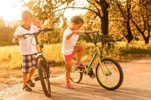 retrato de dos pequeño ciclistas montando su bicicletas foto