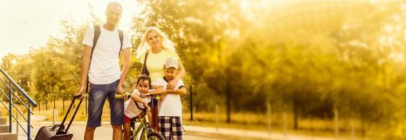 Happy cheerful parents with two kids traveling together photo