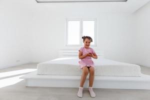 Baby girl relaxing in big parents bed. soft focus photo