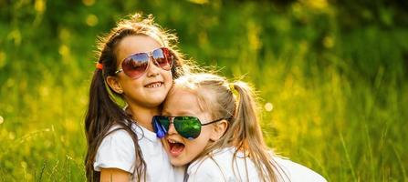 Outdoor portrait of two embracing cute little girls photo
