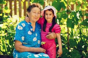 bisabuela y nieta en pie en flor campo en luz de sol foto