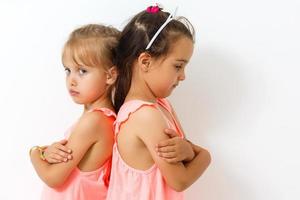 Two young girls in argument over white background photo