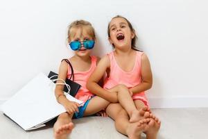 A child, two girls sitting on the floor. Isolated on white background photo