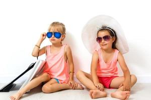 A child, two girls sitting on the floor. Isolated on white background photo