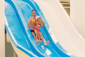 niña y papá feliz divirtiéndose juntos en la piscina al aire libre foto