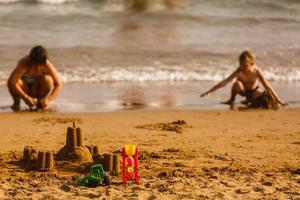children build a castle of sand on the beach photo