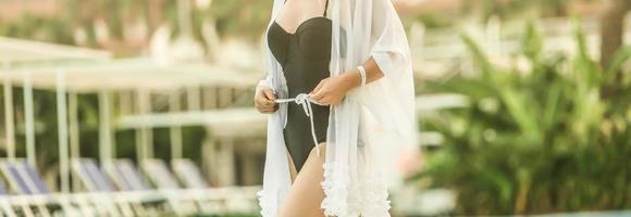 Portrait of a woman wearing a bathrobe standing next to a swimming pool photo