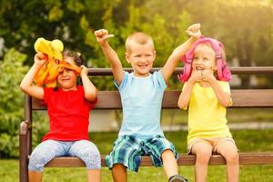 Tres contento niños jugando en el parque a el día tiempo. concepto hermano y hermana juntos Siempre foto