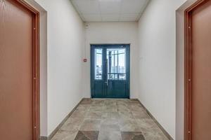 white empty long corridor with red brick walls in interior of modern apartments, office or clinic photo