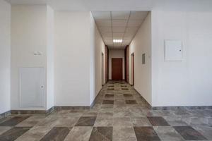 empty long corridor with red brick walls in interior of modern apartments, office or clinic. photo