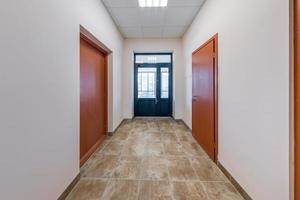 vacío largo corredor con rojo ladrillo paredes en interior de moderno apartamentos, oficina o clínica. foto