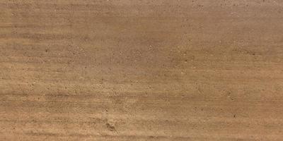 top view of surface of gravel road made of small stones and sand with traces of car tires photo