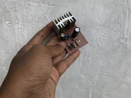 hand holding a component on a radio engine that has been damaged photo