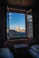 un montaña paisaje fotografiado desde un casa, el ventana formas el marco de el imagen foto