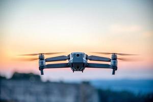 A drone in the air,the background is a purple blurred sky photo