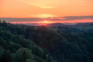 Setting sun behind clouds photo