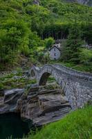 An old stone bridge that stands over a stream photo