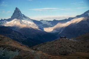 Zermatt mountain landscape, the mountains are illuminated by the sun.in the distance stands an inn photo
