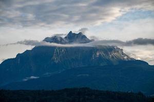 un ciudad con un enorme montaña en el antecedentes durante el puesta de sol foto