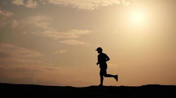 silhouette di uomo in esecuzione liberamente contento nel bellissimo sera leggero video