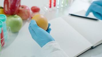 forskare kolla upp kemisk frukt rester i laboratorium. kontrollera experter inspektera de koncentration av kemisk rester. faror, standard, hitta förbjuden ämnen, förorena, mikrobiolog video