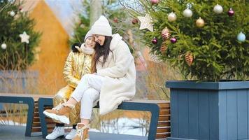 Adult woman and young girl together at outdoor ice skating rink video