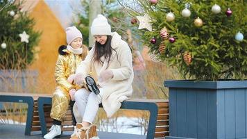 Adult woman and young girl together at outdoor ice skating rink