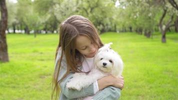 Young girl with pet dog outside on grass video