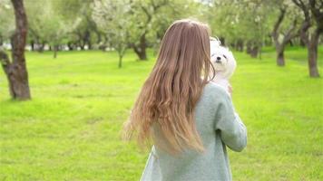 Young girl with pet dog outside on grass video