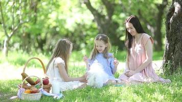 familj picknick på de gräs med mor och döttrar video