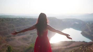 Young girl stands with arms open before scenic view video