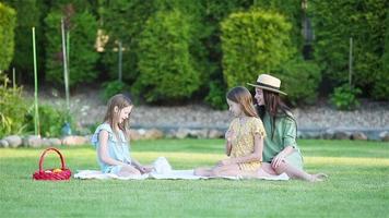 Family picnic on the grass with mother and daughters video