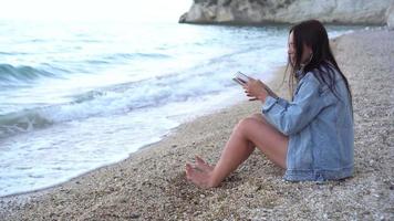 mulher sentado em rochoso de praia video