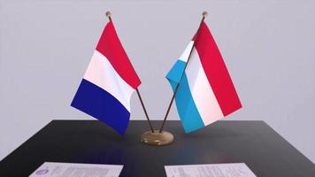 Luxembourg and France national flags on table in diplomatic conference room. Politics deal agreement video