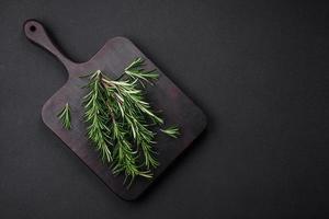 Sprigs of fresh green rosemary on a wooden cutting board photo