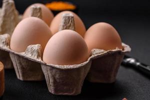 Fresh raw chicken eggs in beige color in a cardboard tray photo