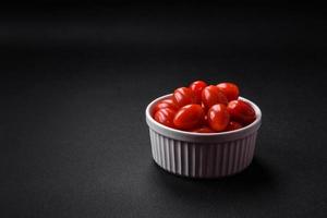 Fresh tasty cherry tomatoes in a white ribbed bowl photo